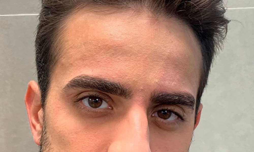 Close-up of a person with brown eyes and dark hair looking at the camera.