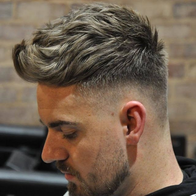 Side profile of a man with a stylish textured haircut and a neatly trimmed beard.